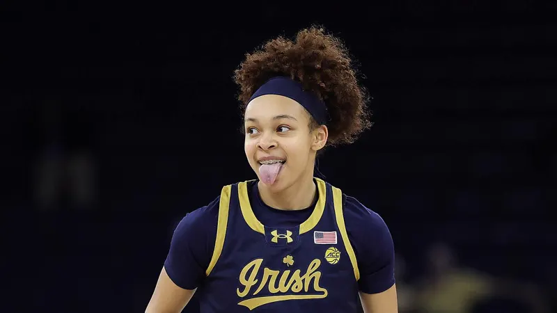 Hannah Hidalgo sticking out her tongue during a game in Notre Dame's navy uniform